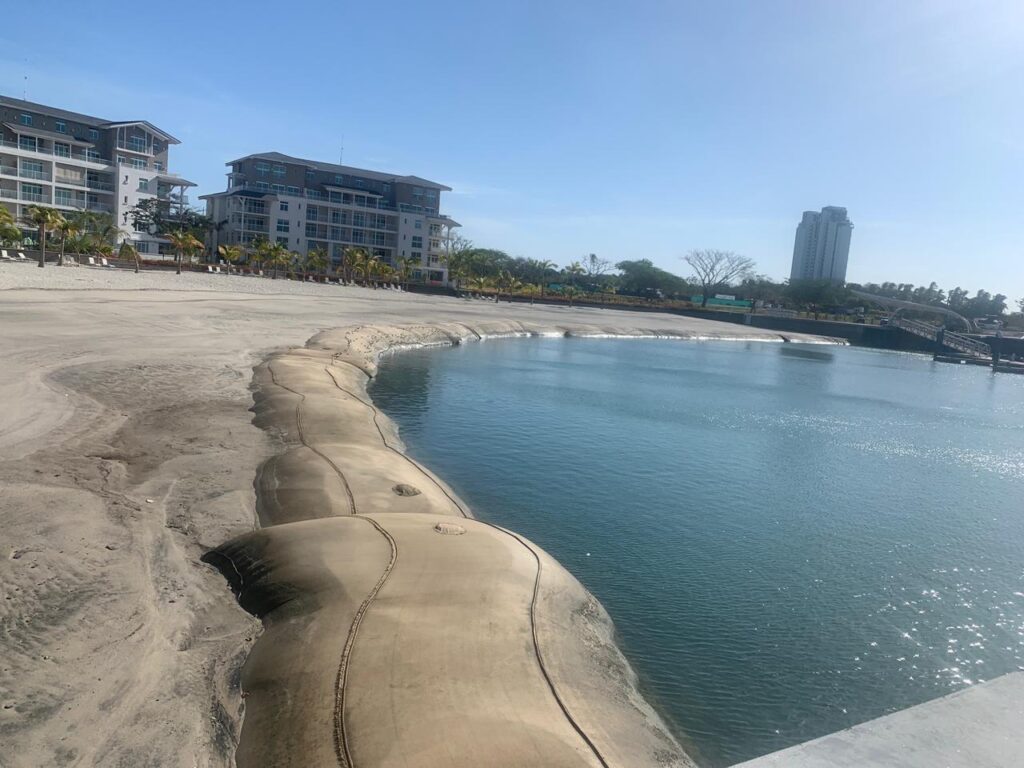 TITANTube® completed marina shoreline revetment — sand-colored tubes forming curved perimeter