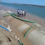 La Trocha geotextile tube installation — pump crews filling TITANTubes along the shoreline