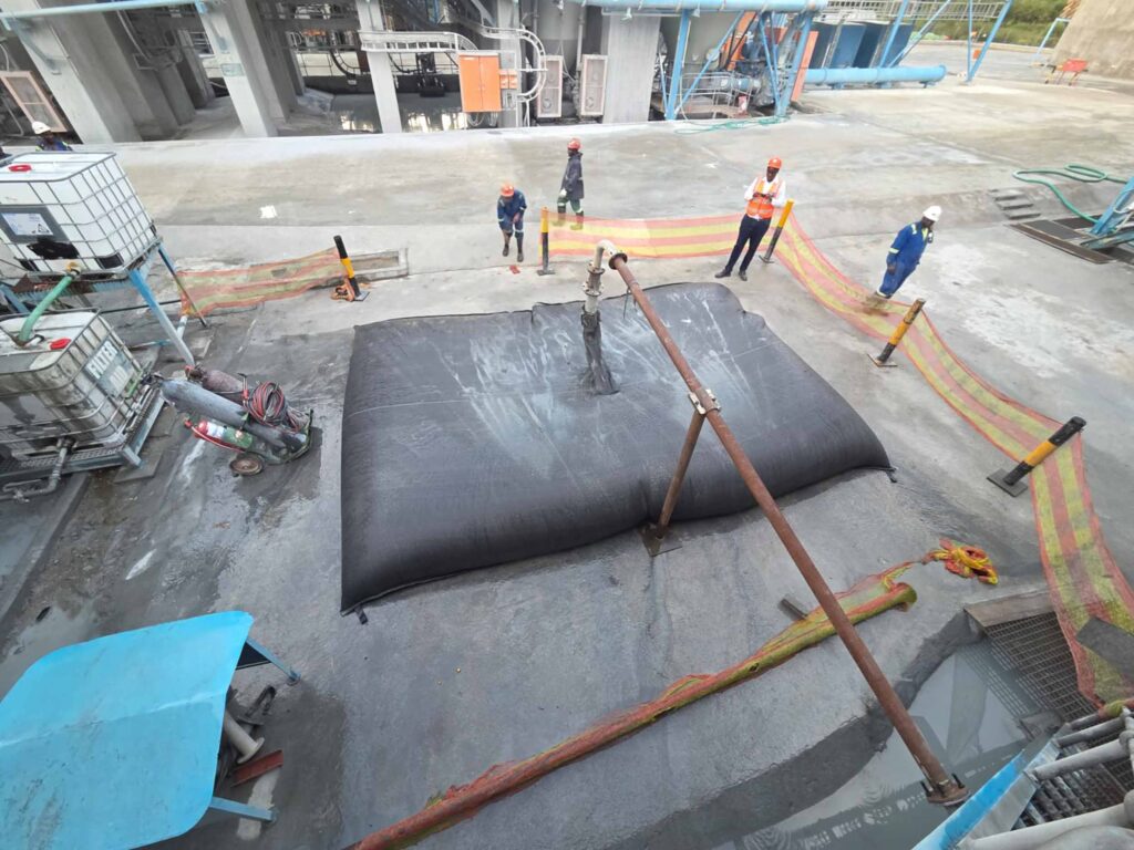 TITANTube® industrial dewatering — overhead view of tube filling on concrete pad with crew